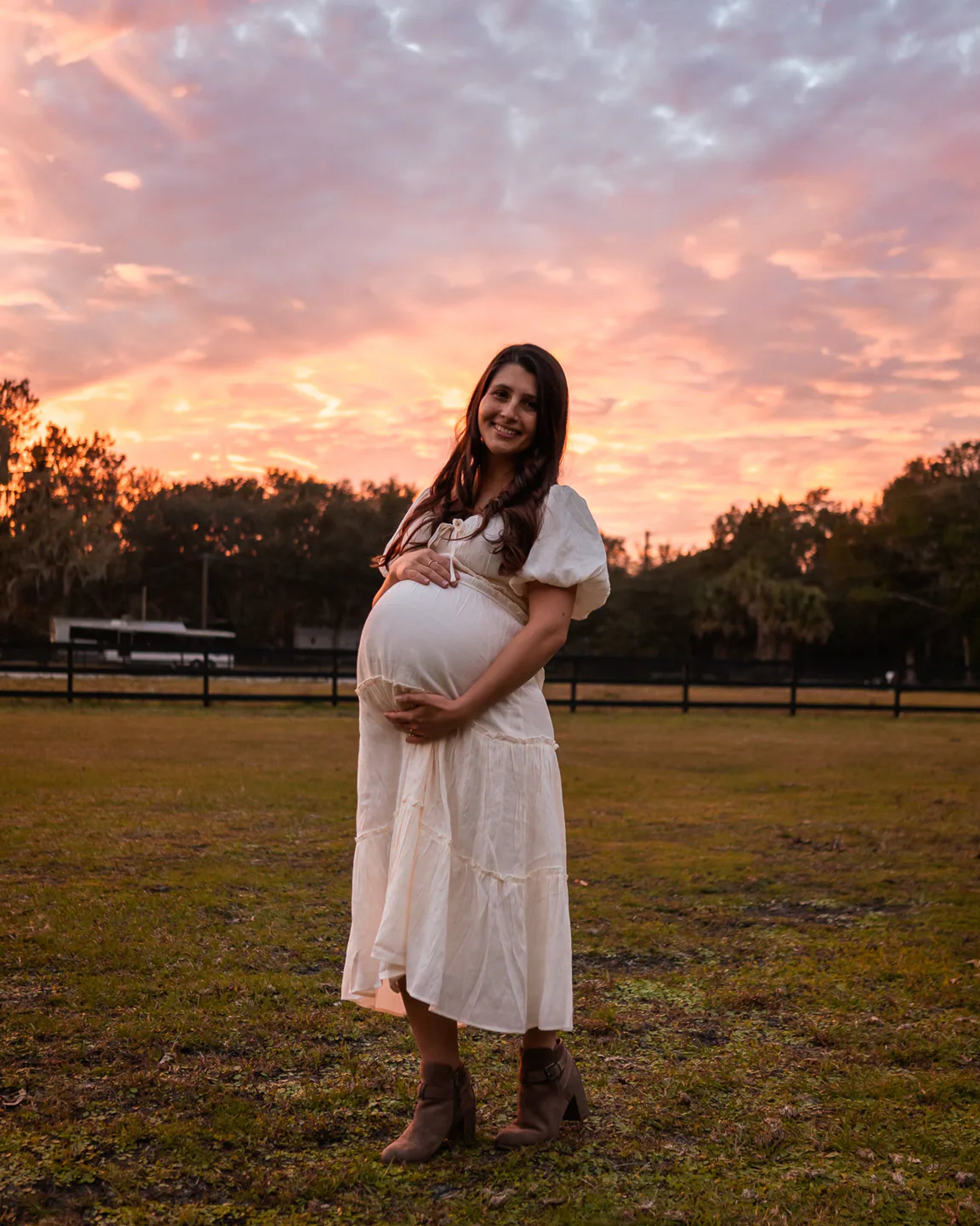 Pregnant mother in white dress during outdoor maternity photos in Florida