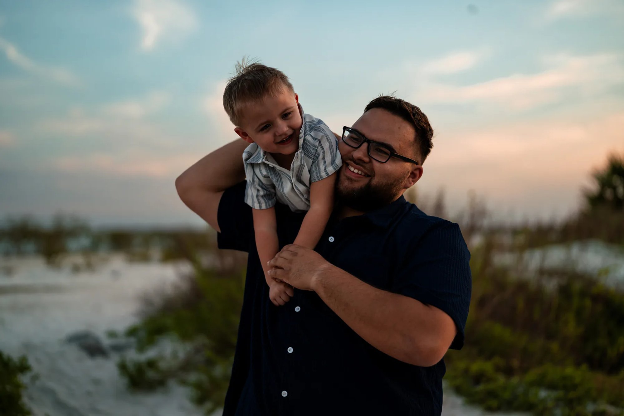 Father laughing with child during candid family photos at Ponce Inlet Beach