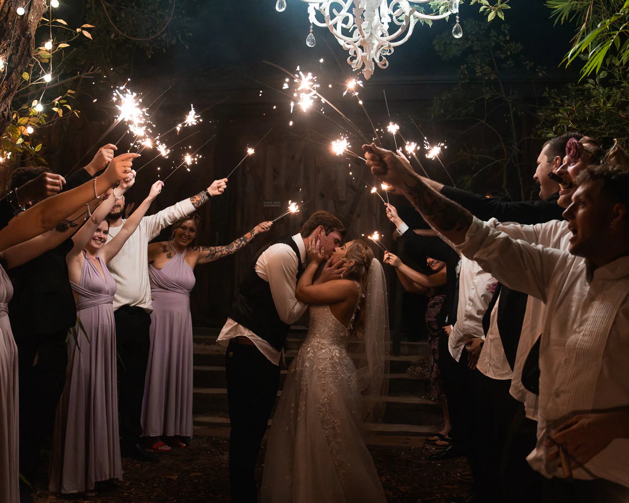 Bride and groom sparkler exit kiss at nighttime Bridle Oaks Barn wedding in DeLand Florida