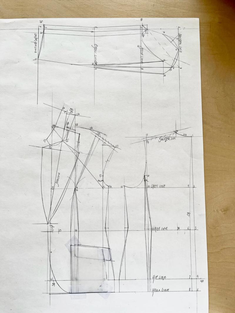 Hand-drawn pattern pieces on tracing paper with construction lines, curves, and measurement annotations.