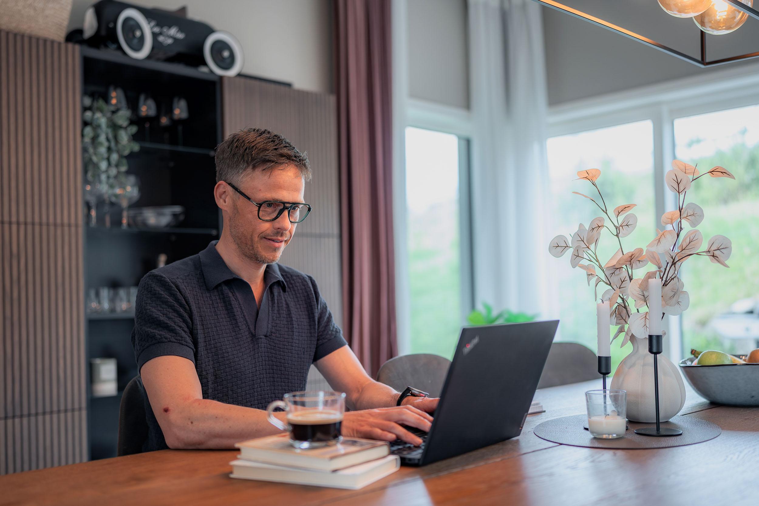 Mann med briller jobber på laptop