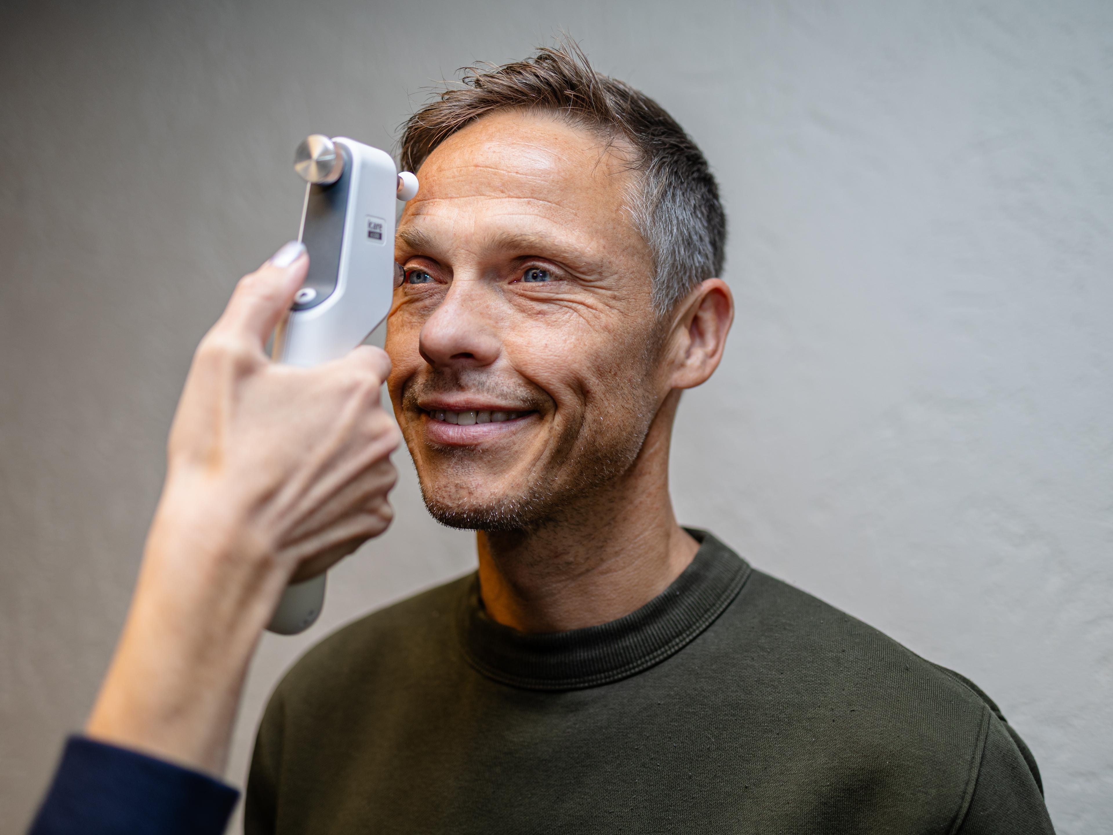 Optiker måler øyetrykket til en kunde