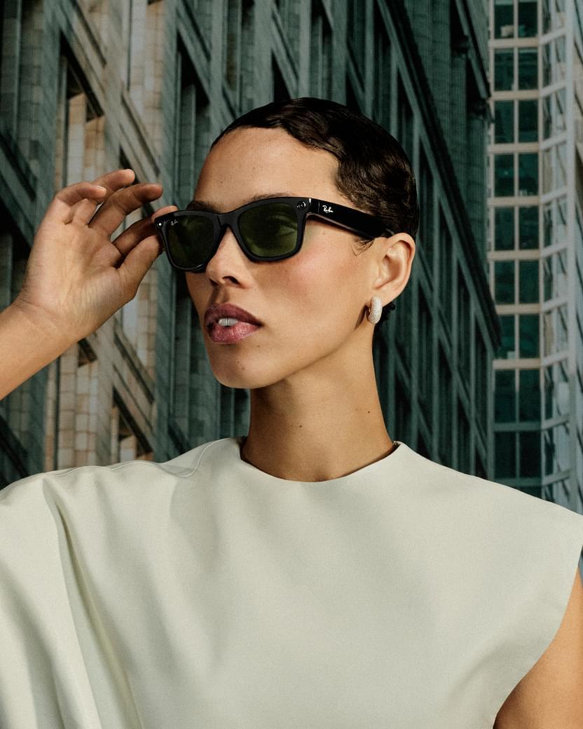 Kvinne med Ray-Ban Meta Wayfarer solbriller foran en bygning