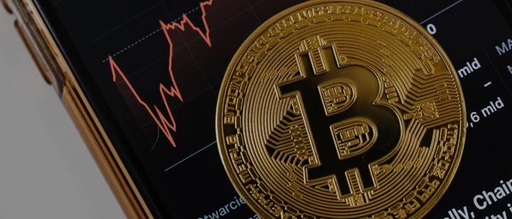 Crypto trading chart behind a bitcoin coin, the only market our trading software development covers