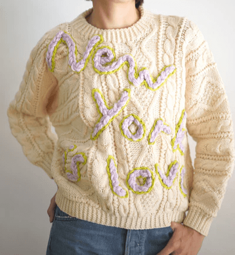 A girl wearing a sustainable vintage hand embroidered sweater.