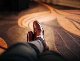 Brown leather dress shoes worn with black and white polka dotted socks.
