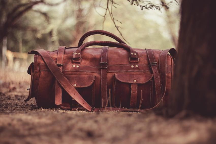 brown leather duffle bag on ground