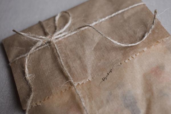 Brown envelop packaging with a twine bow on top.