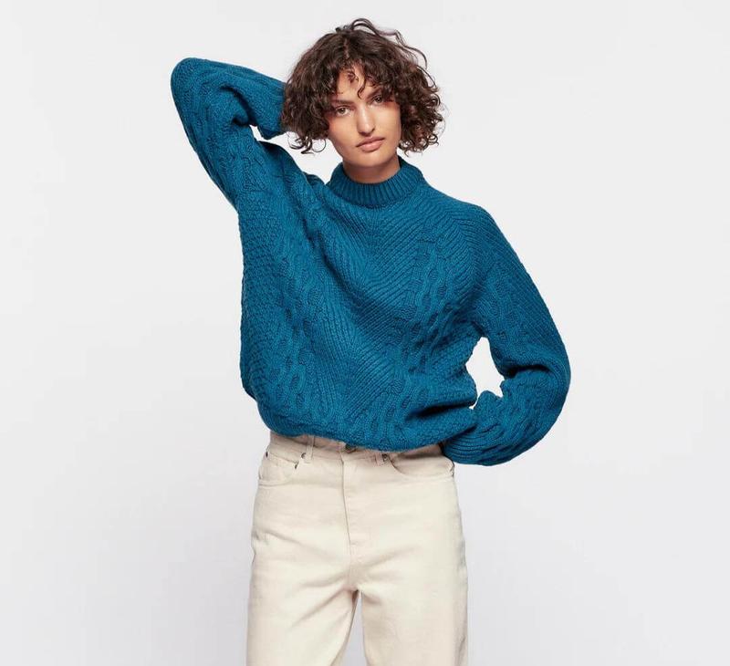 A woman in a blue green knitwear.