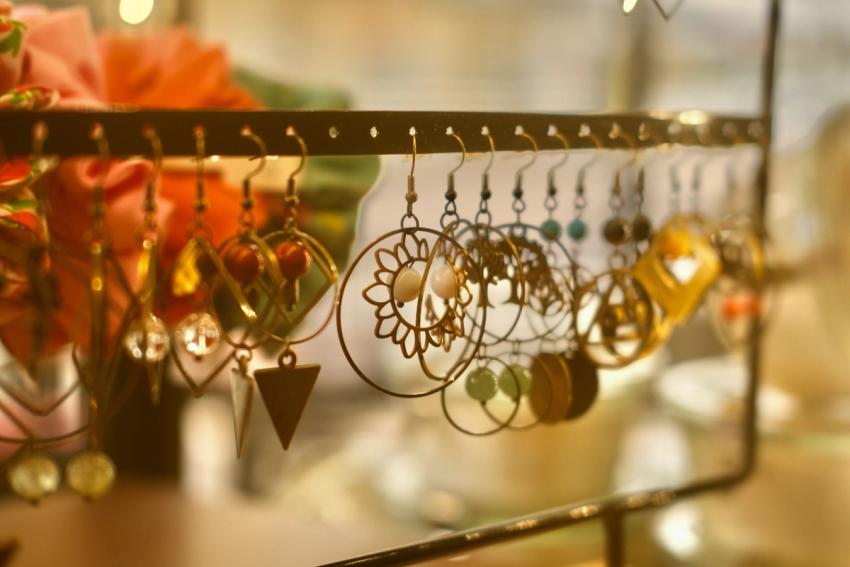 Variety of gold earring hoops hanging on a rack.