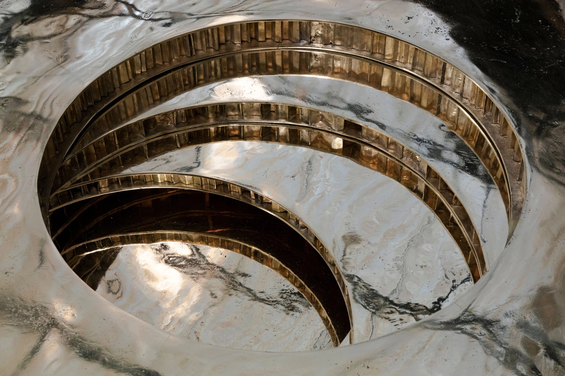 Brass rings set into a bowl carved out of veined marble.