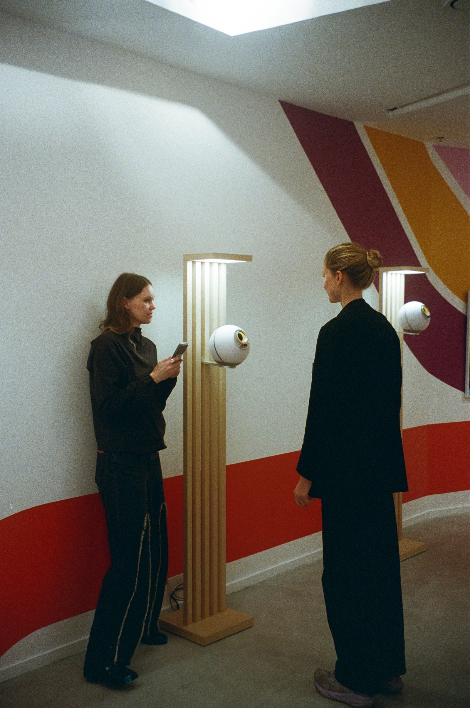 Two people standing beside a World orb
