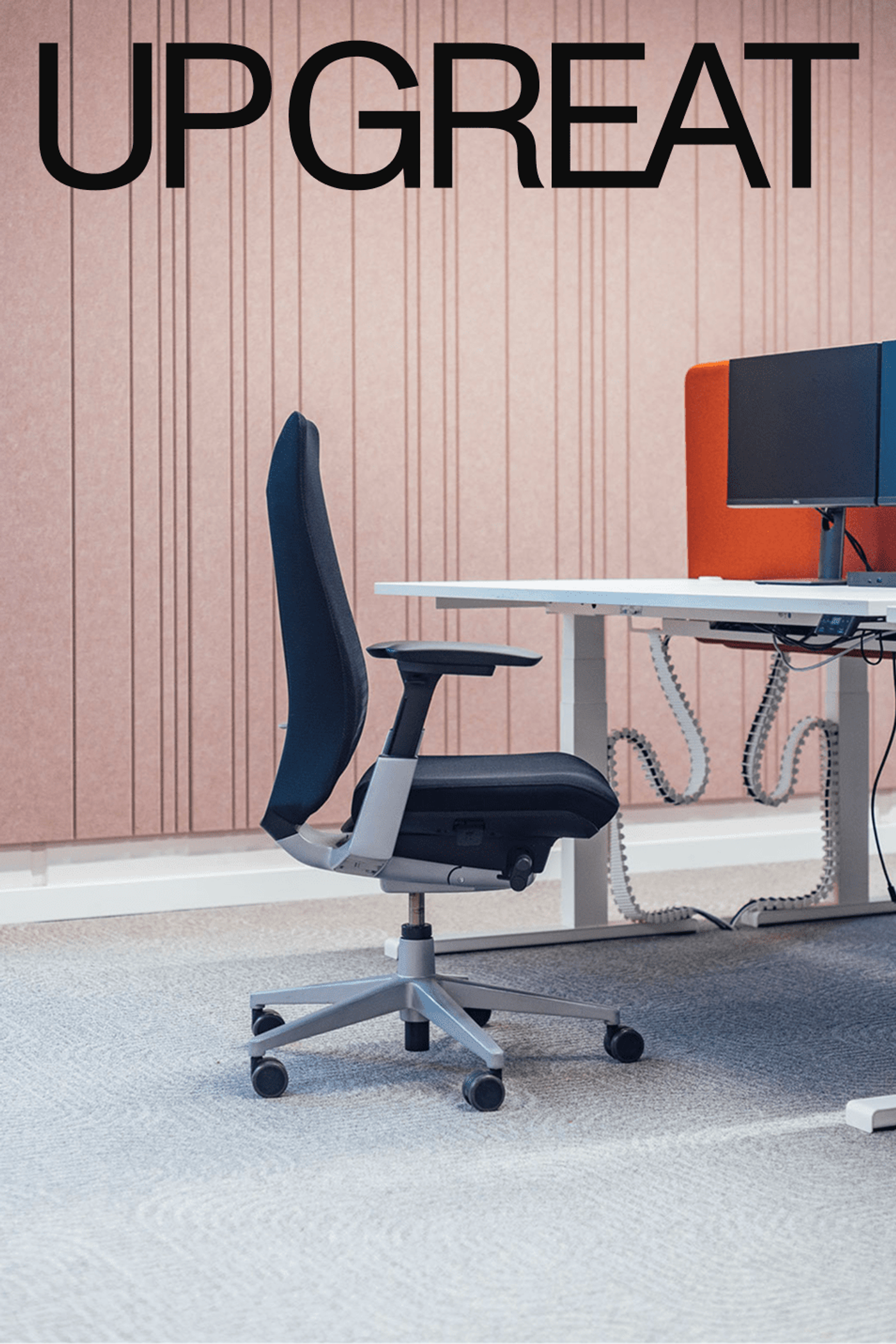 An office chair at a white desk in front of a pink panelled wall, under the UP GREAT name.
