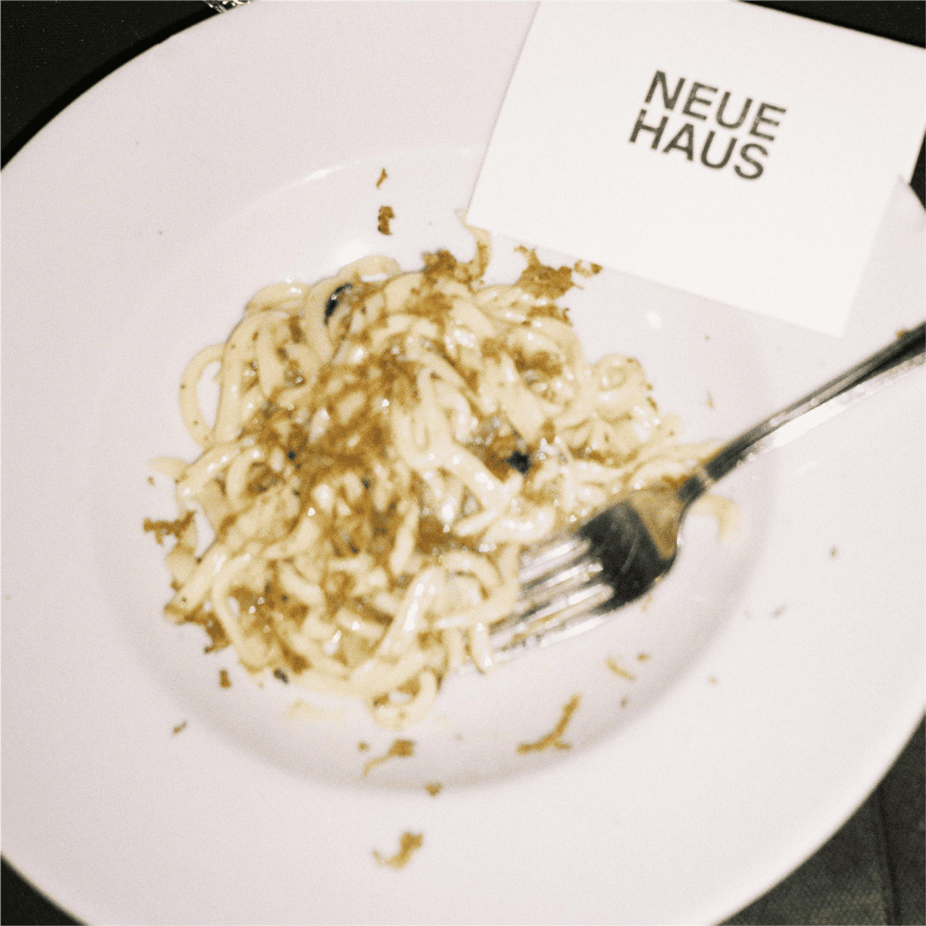 A plate of pasta with a NeueHaus place card laid on it.
