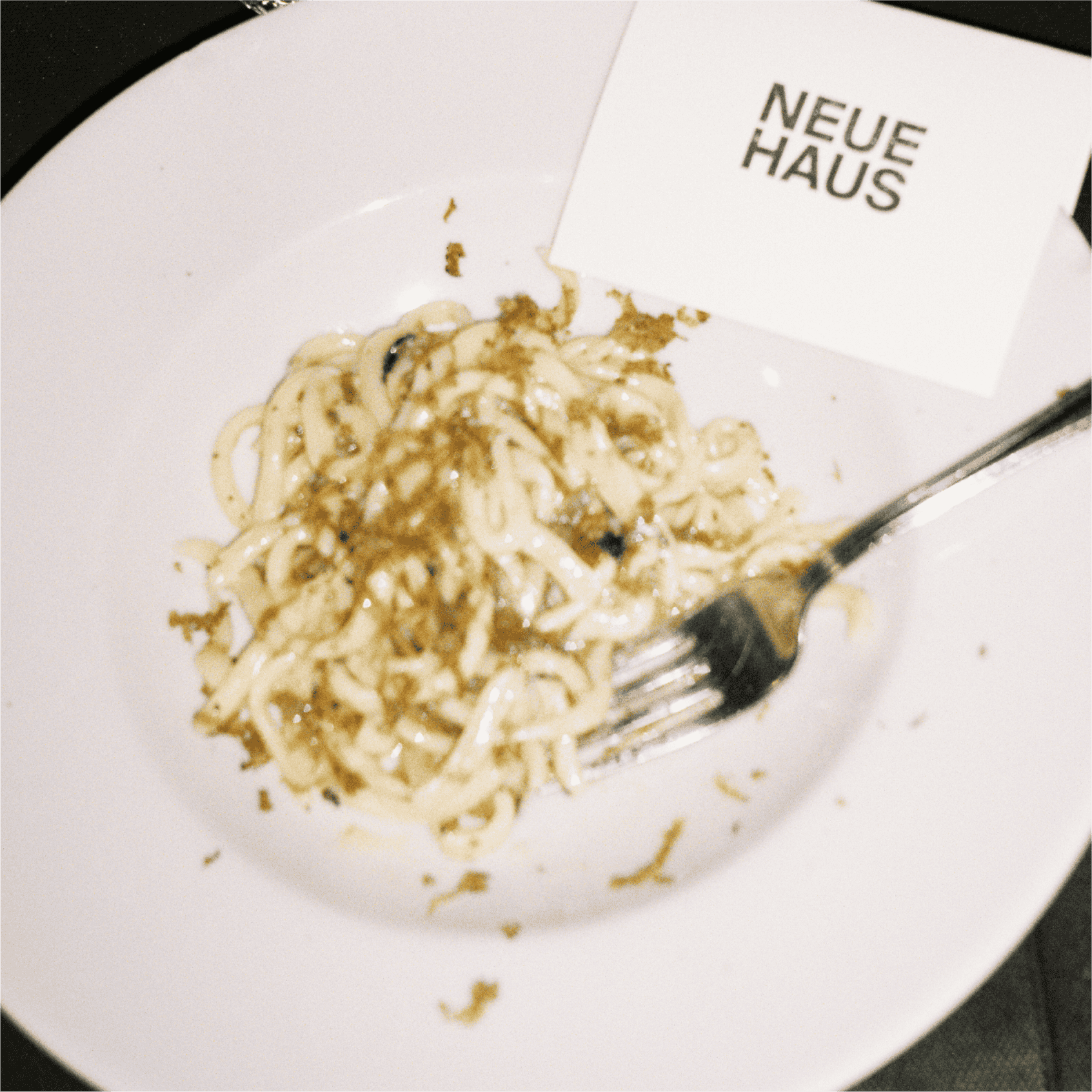 A plate of pasta with a NeueHaus place card laid on it.