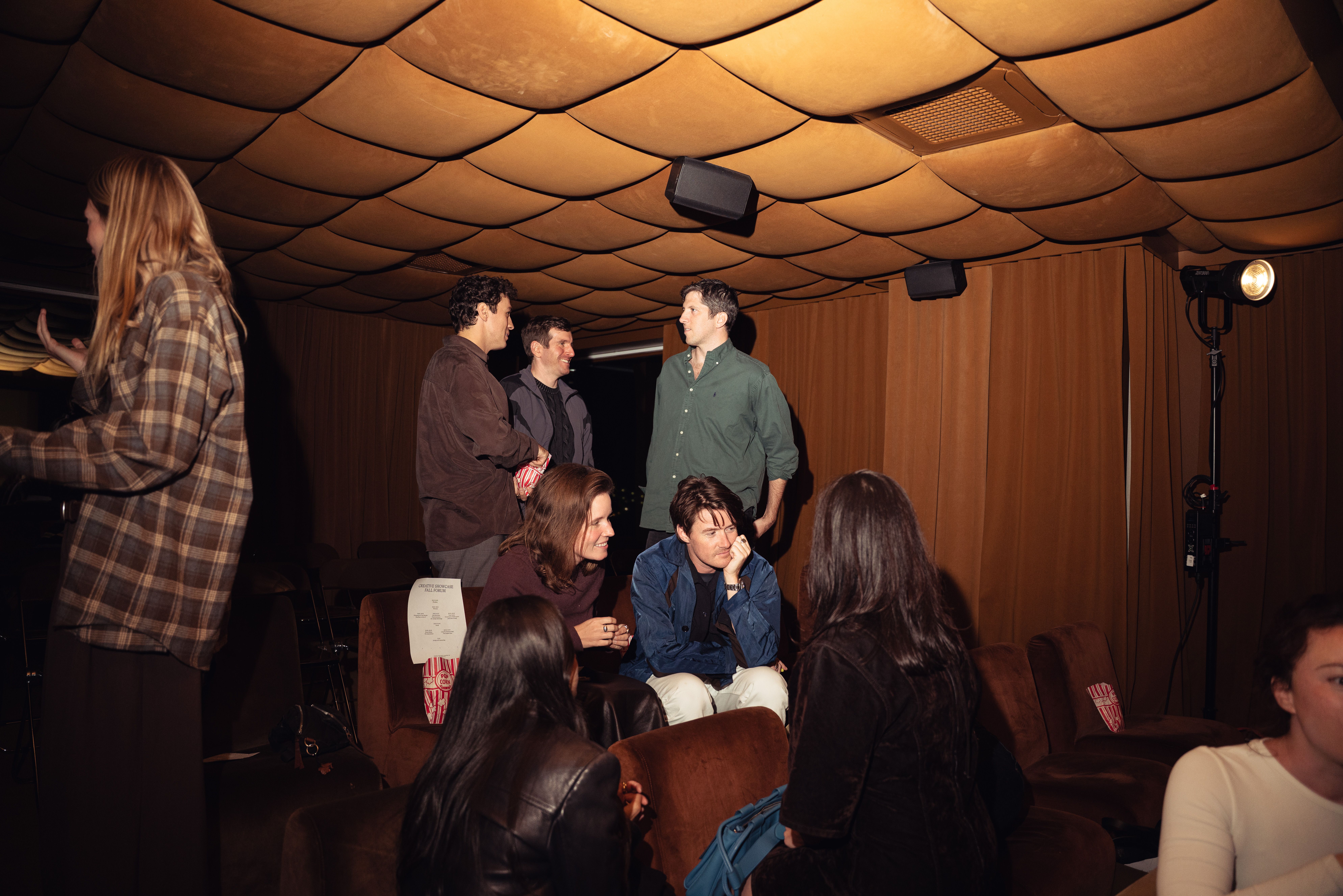 A cinema room full with audience and speakers sitting on the stage