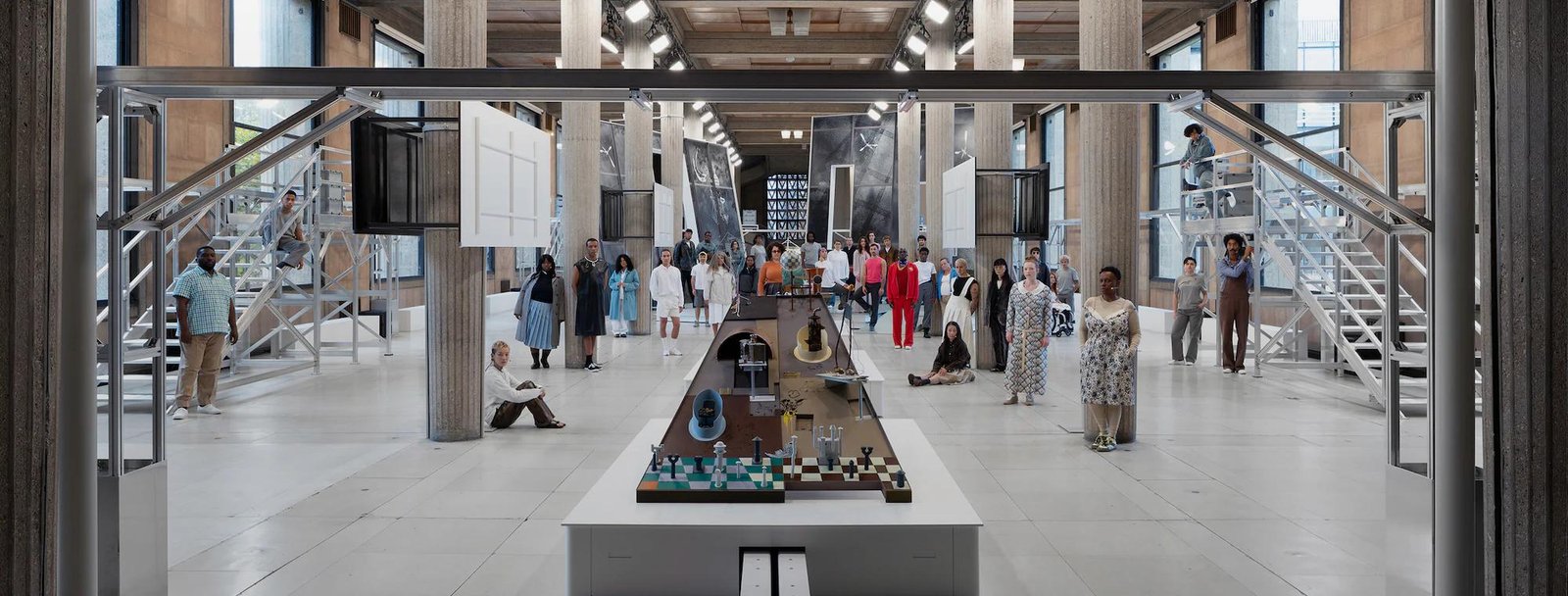 A design fair in a glass roofed hall, with a long model laid out on a plinth.