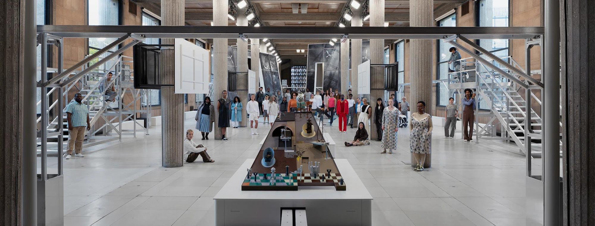 A design fair in a glass roofed hall, with a long model laid out on a plinth.