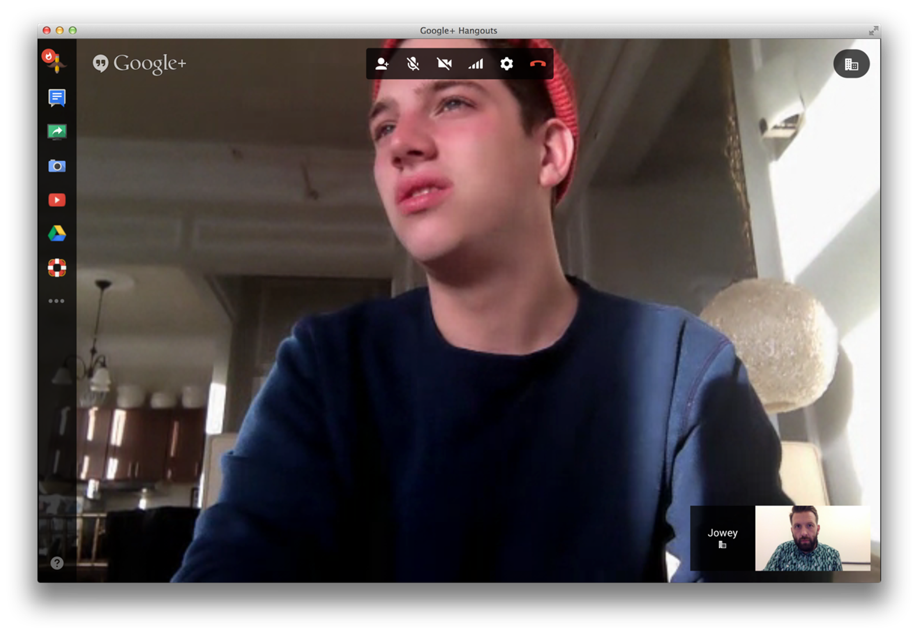 A video call on a laptop screen, a young man talking from a bright room.