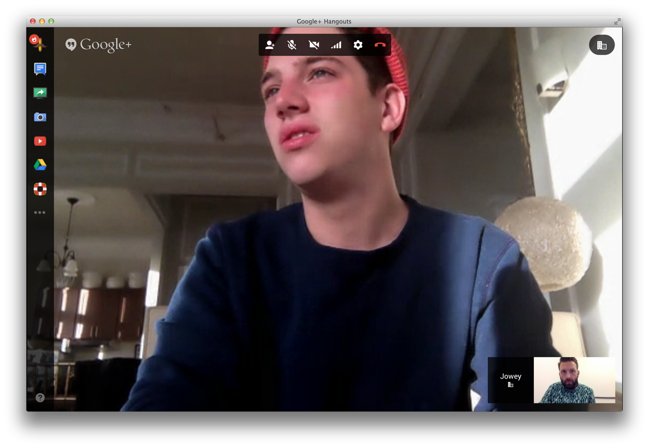 A video call on a laptop screen, a young man talking from a bright room.