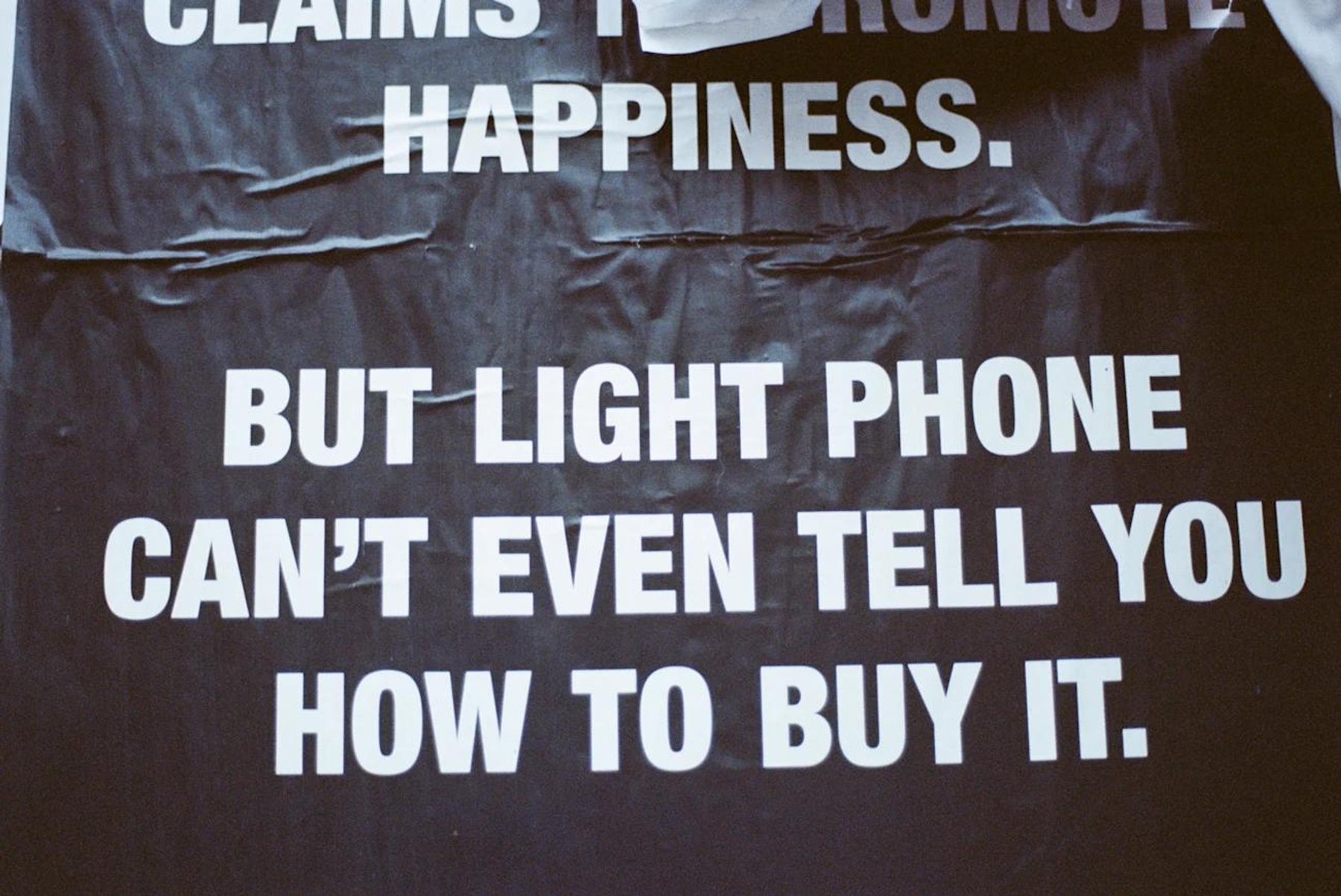 A poster reading that the Light Phone cannot even tell you how to buy it.