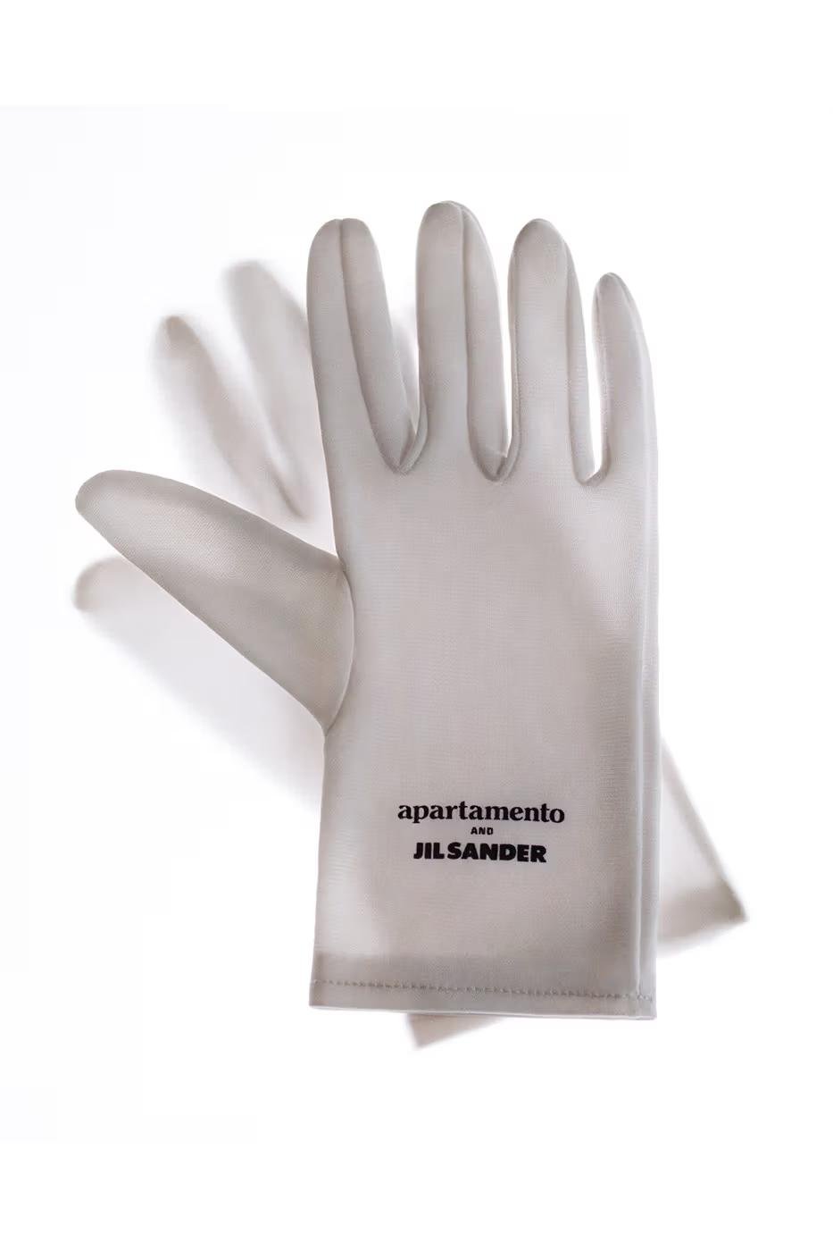 A pale glove printed with the Apartamento and Jil Sander names.