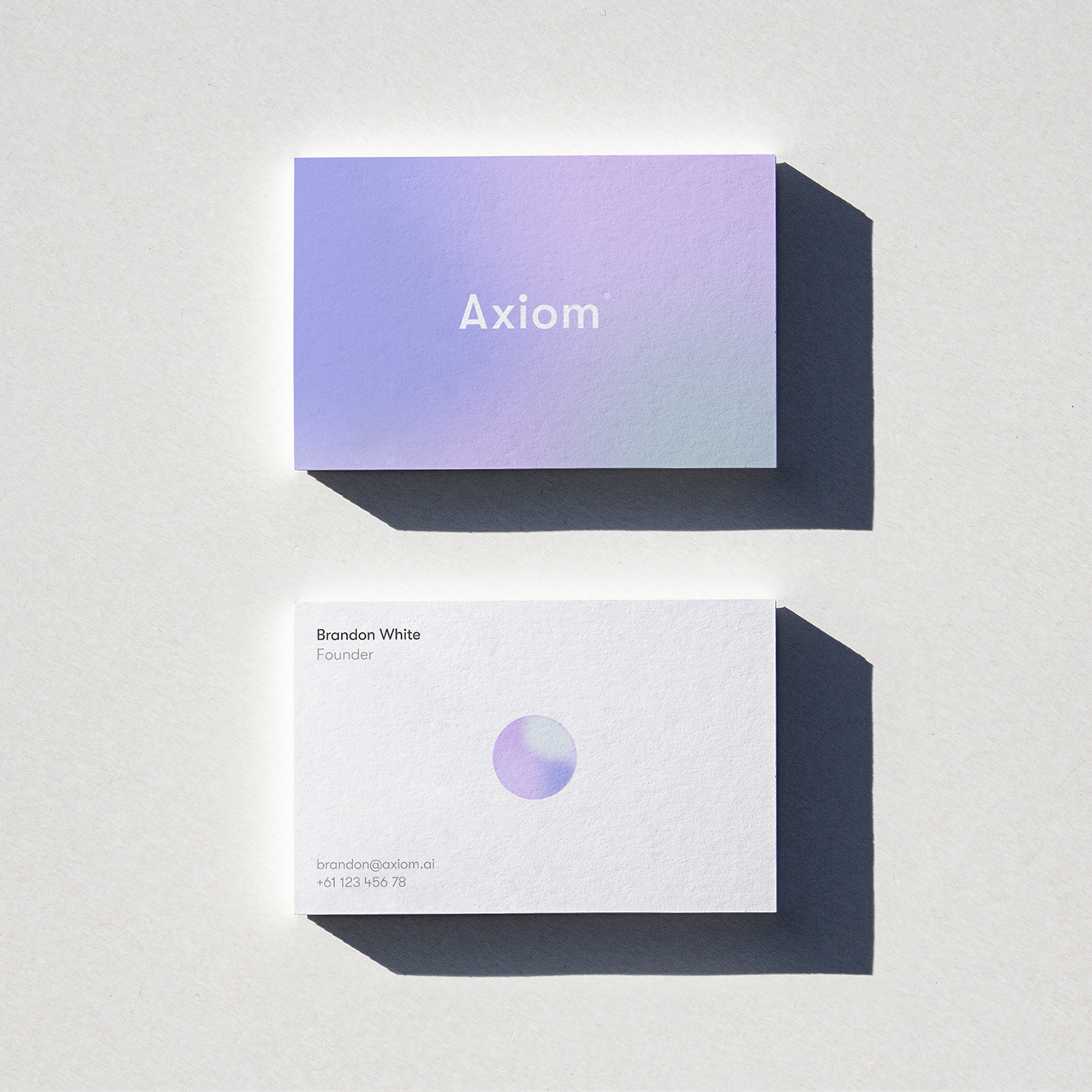 Axiom business cards with the lilac gradient and the orb