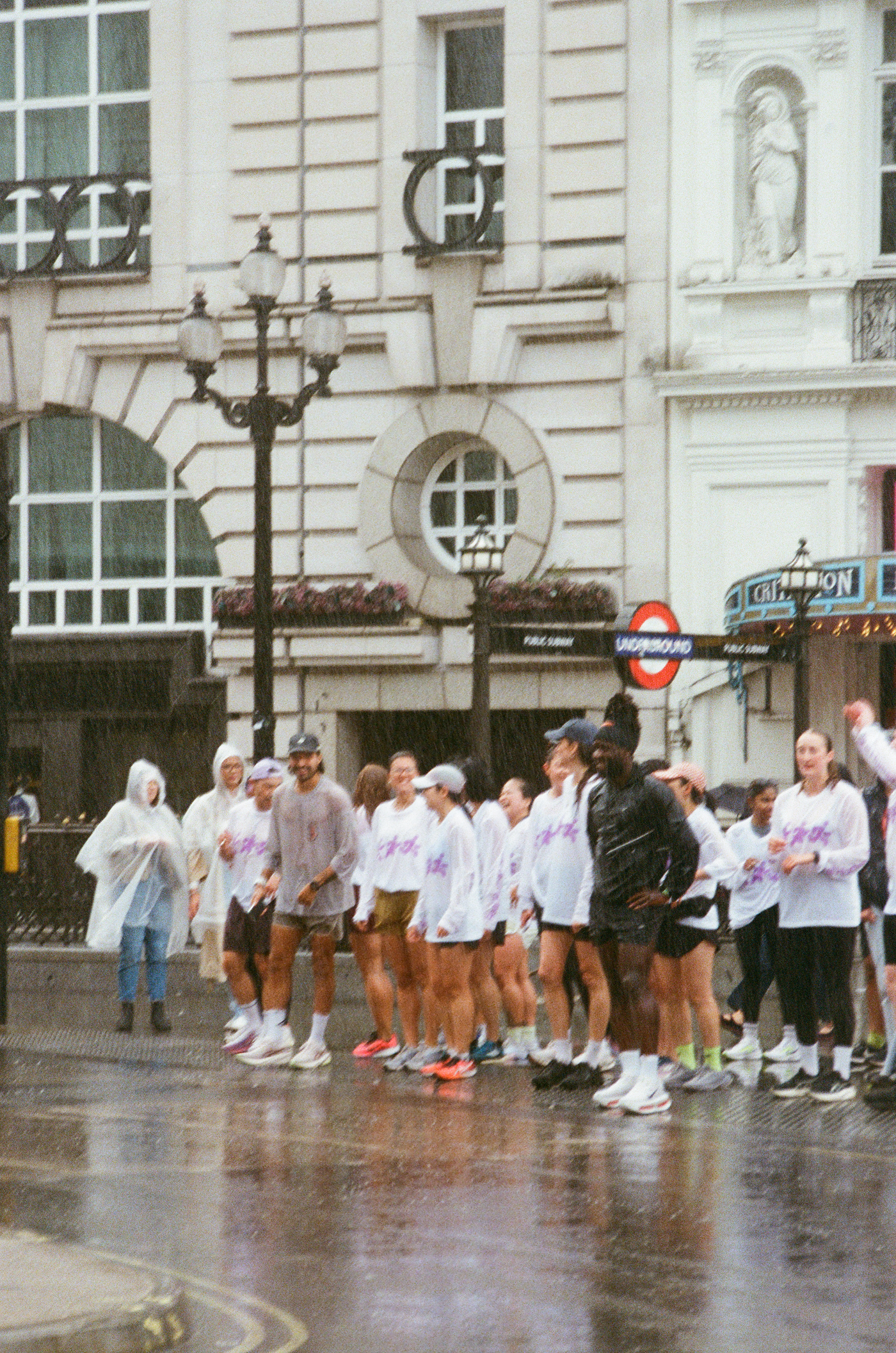 Runners crossing a London street in the rain.