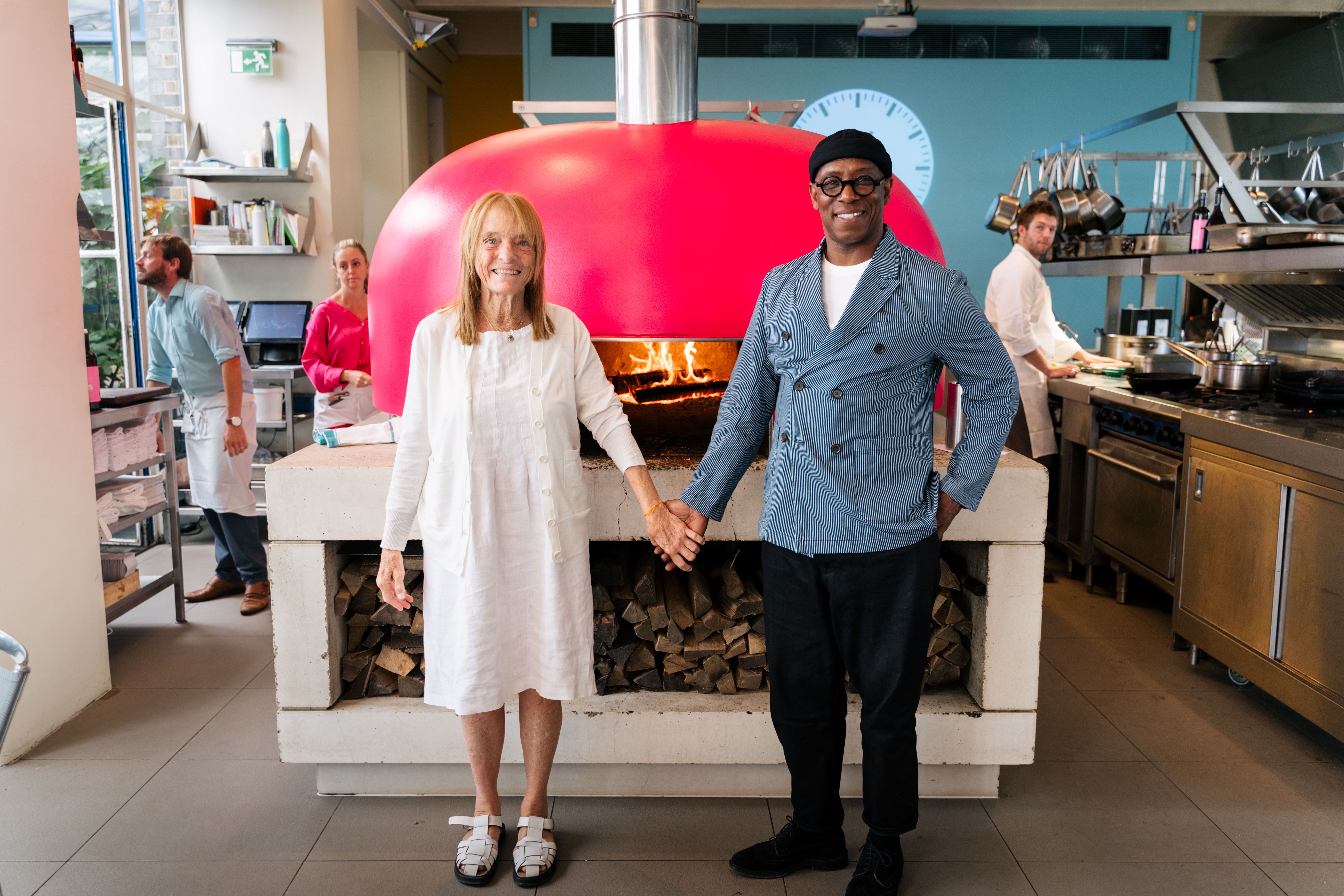 Ruthie Rogers and Ian Wright stood in front of a pink pizza oven