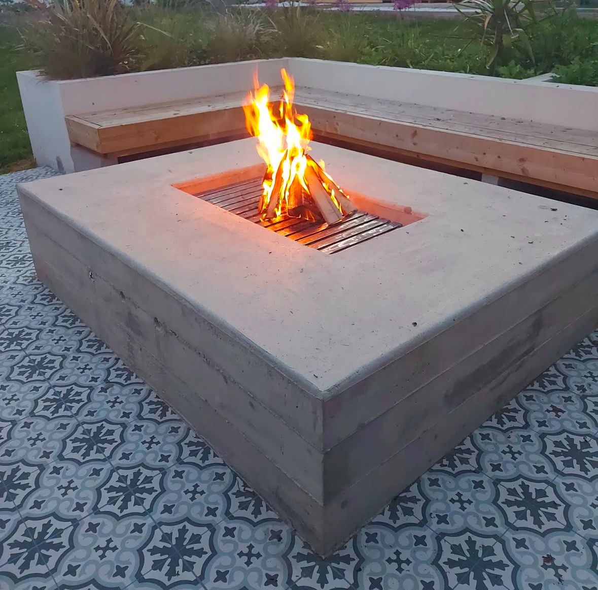 Completed project image: A modern fire pit with metal grill and surrounding concrete worktop