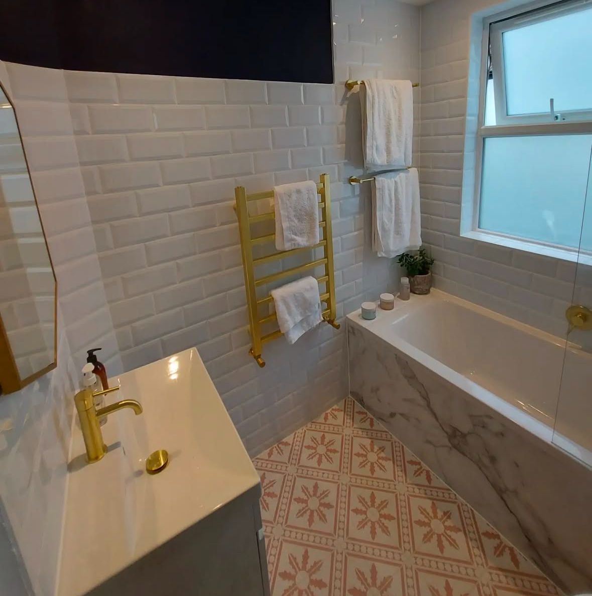 Completed project- Modern bathroom design with smooth white wall tiles, creative flower laminate floor, marble sink and marble side bath panels
