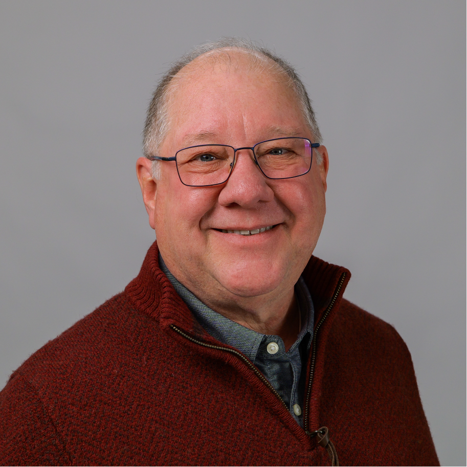 A headshot of a man in a red sweater.