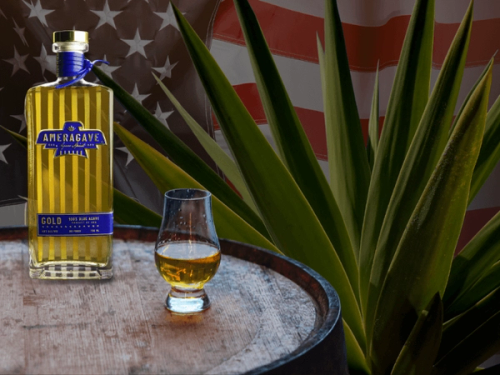 Ameragave bottle on barrel in front of American flag and an agave plant