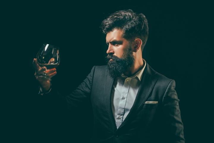 Man with beard looking at glass