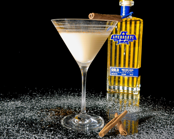 Martini glass with white drink sprinkled with cinnamon