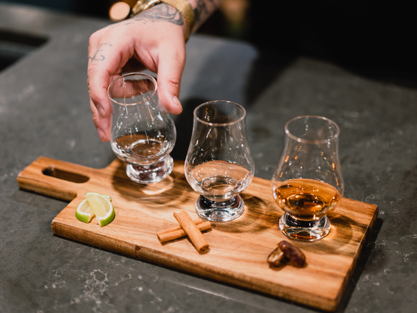 Three glasses on wooden table with different types of tequila