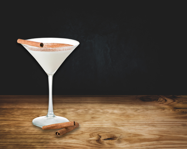 Martini glass with white drink sprinkled with cinnamon