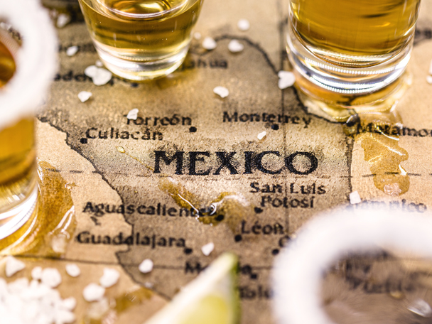 Map of a portion of Mexico with glasses of tequila and lime sitting on map