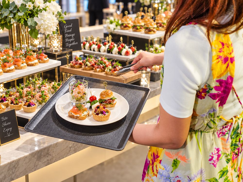ビュッフェ台からカナッペやスライダーを取り分けるご来場者