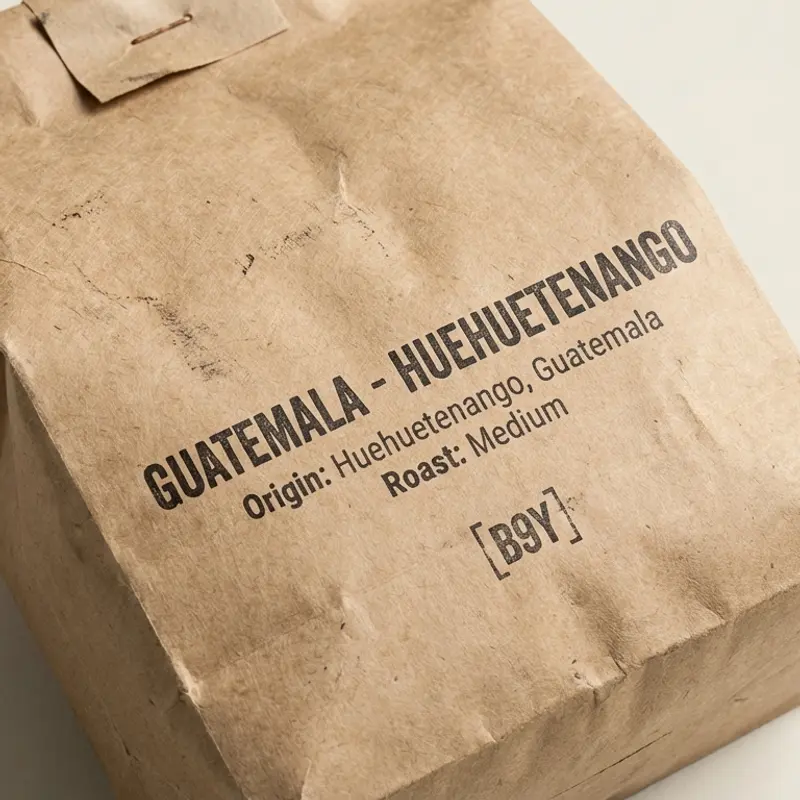 Specialty coffee bag of Guatemala - Huehuetenango with medium roast, photographed on a bone background with diffused lighting.