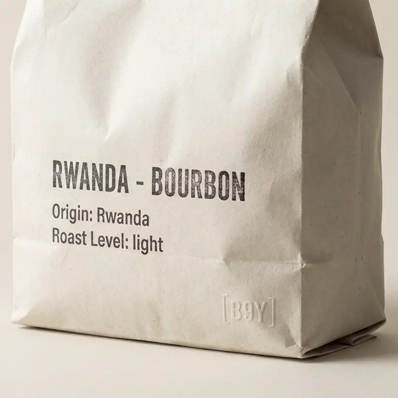 A specialty coffee bag labeled 'Rwanda - Bourbon' with a light roast, photographed on a bone/off-white background.