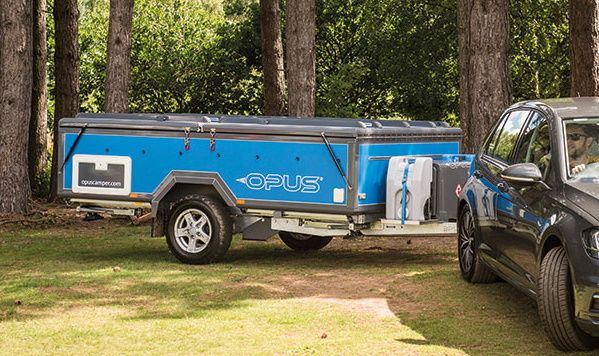 Blue Opus being towed in a wooded area