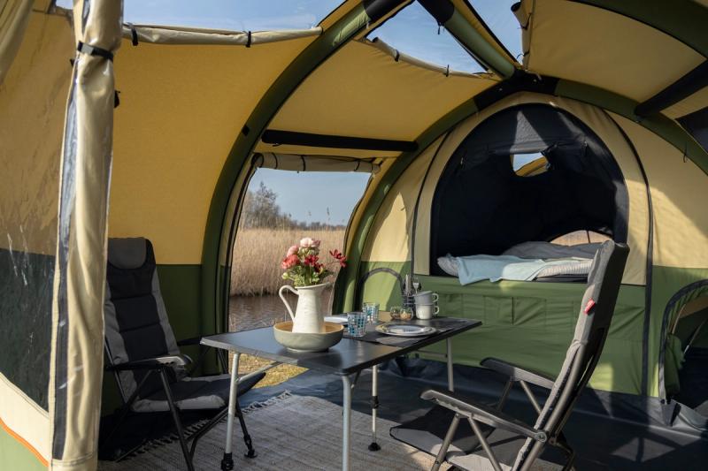 Interior of Alpenkreuzer OpenAir trailer tent, with open door and camping furniture