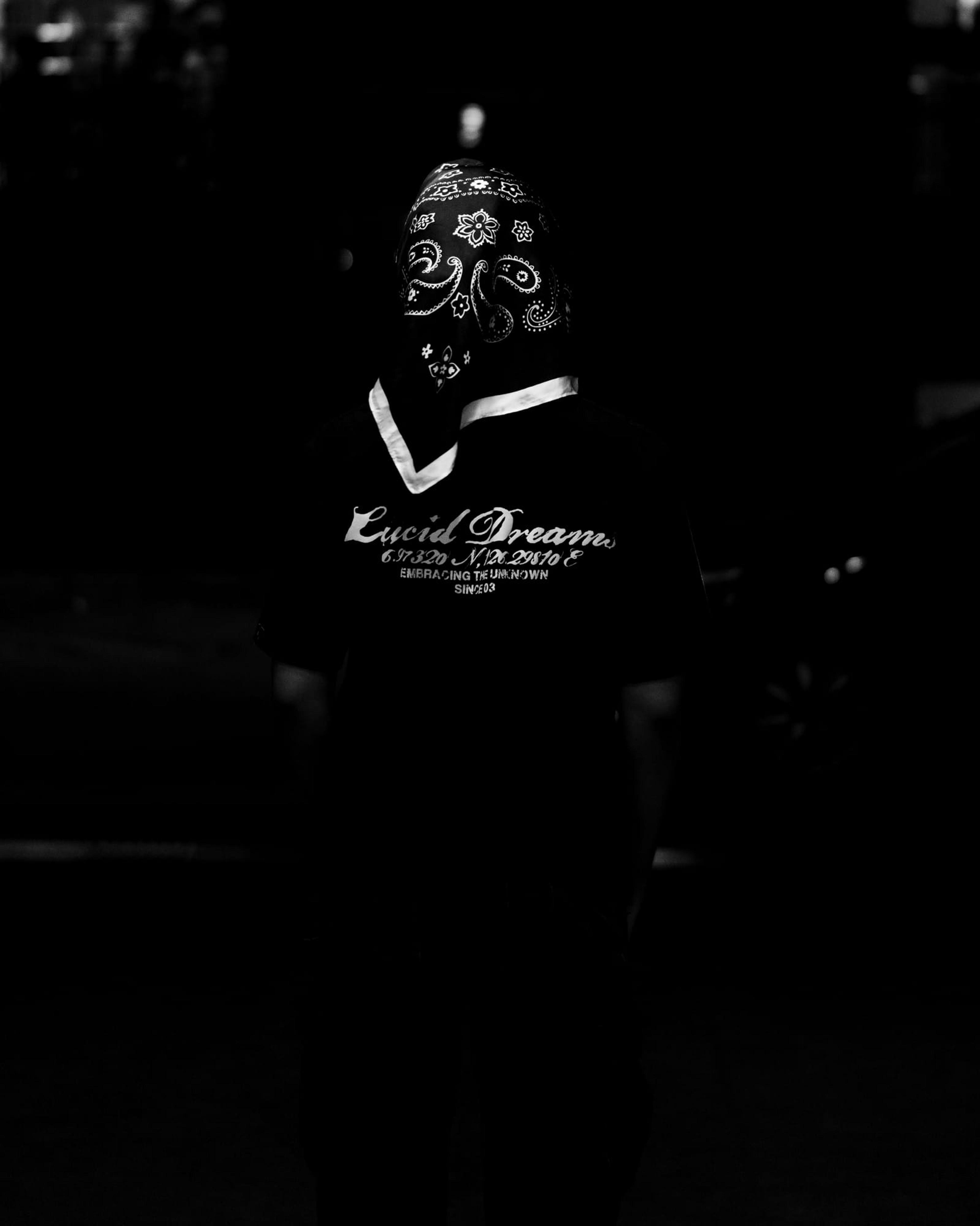 The back print of the LD Signature Shirt in Black, worn, at night