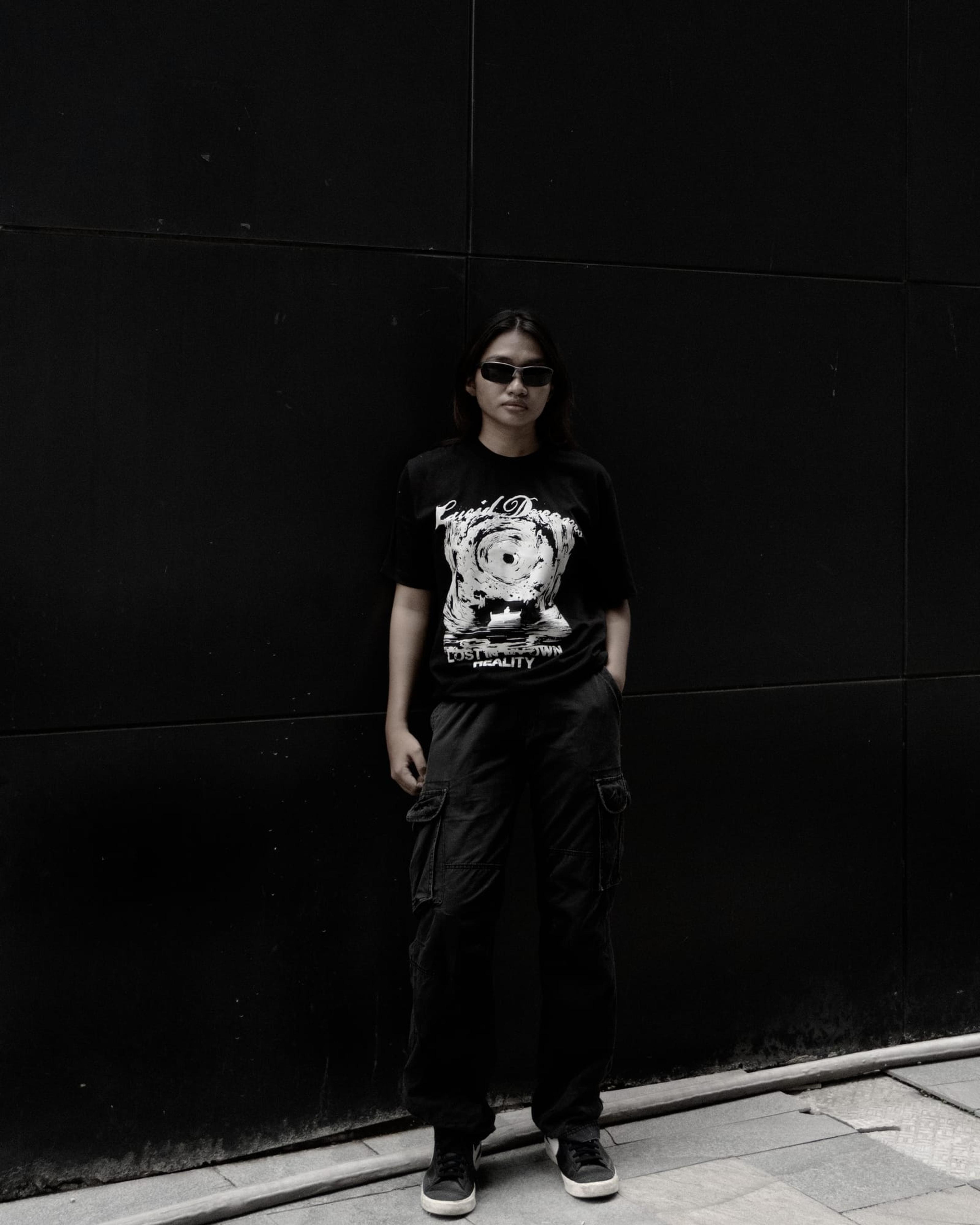 A model wearing the LD Signature Shirt in Black against a dark wall