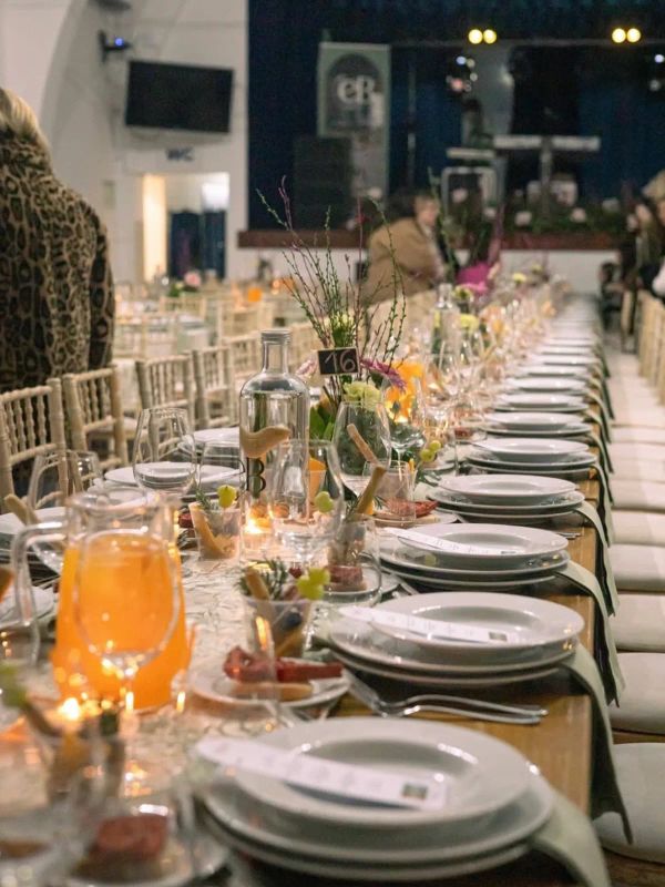 Mesa comprida de catering com centros de mesa e garrafas EB Catering