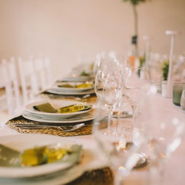 Lugar à mesa com tábua de palha, menu em tecido e mini garrafa de azeite