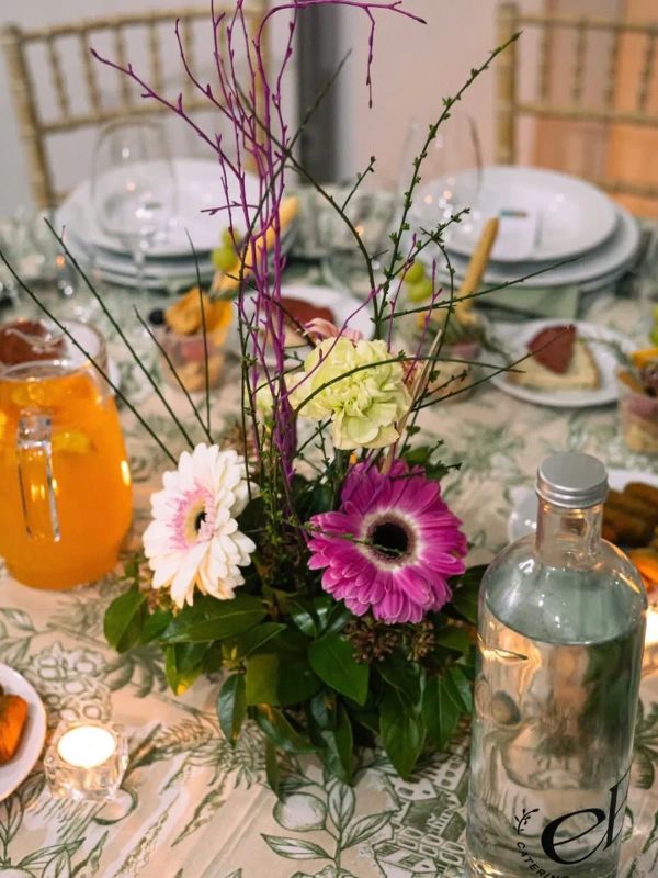 Centro de mesa com gerberas e garrafa EB Catering