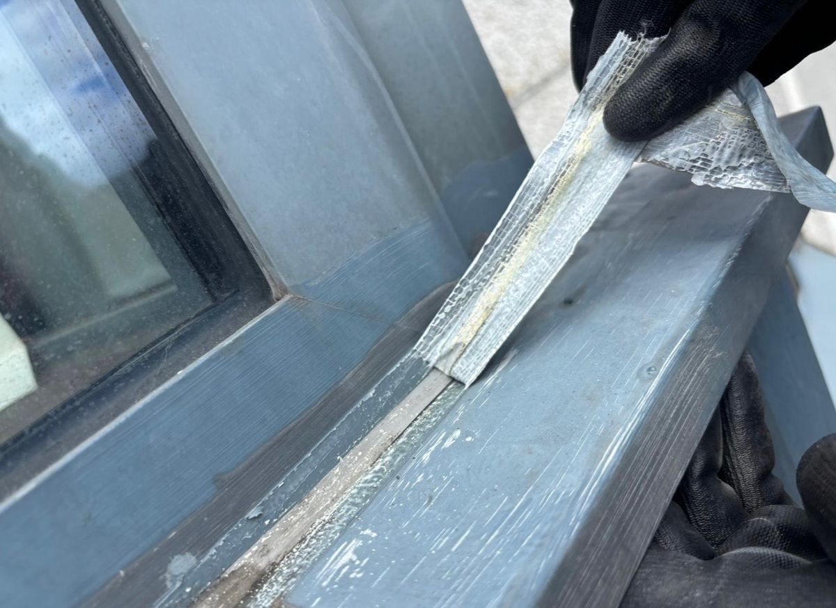 Removal of the previous repair during rope access investigation of water ingress around the high-rise window system in Newcastle upon Tyne.