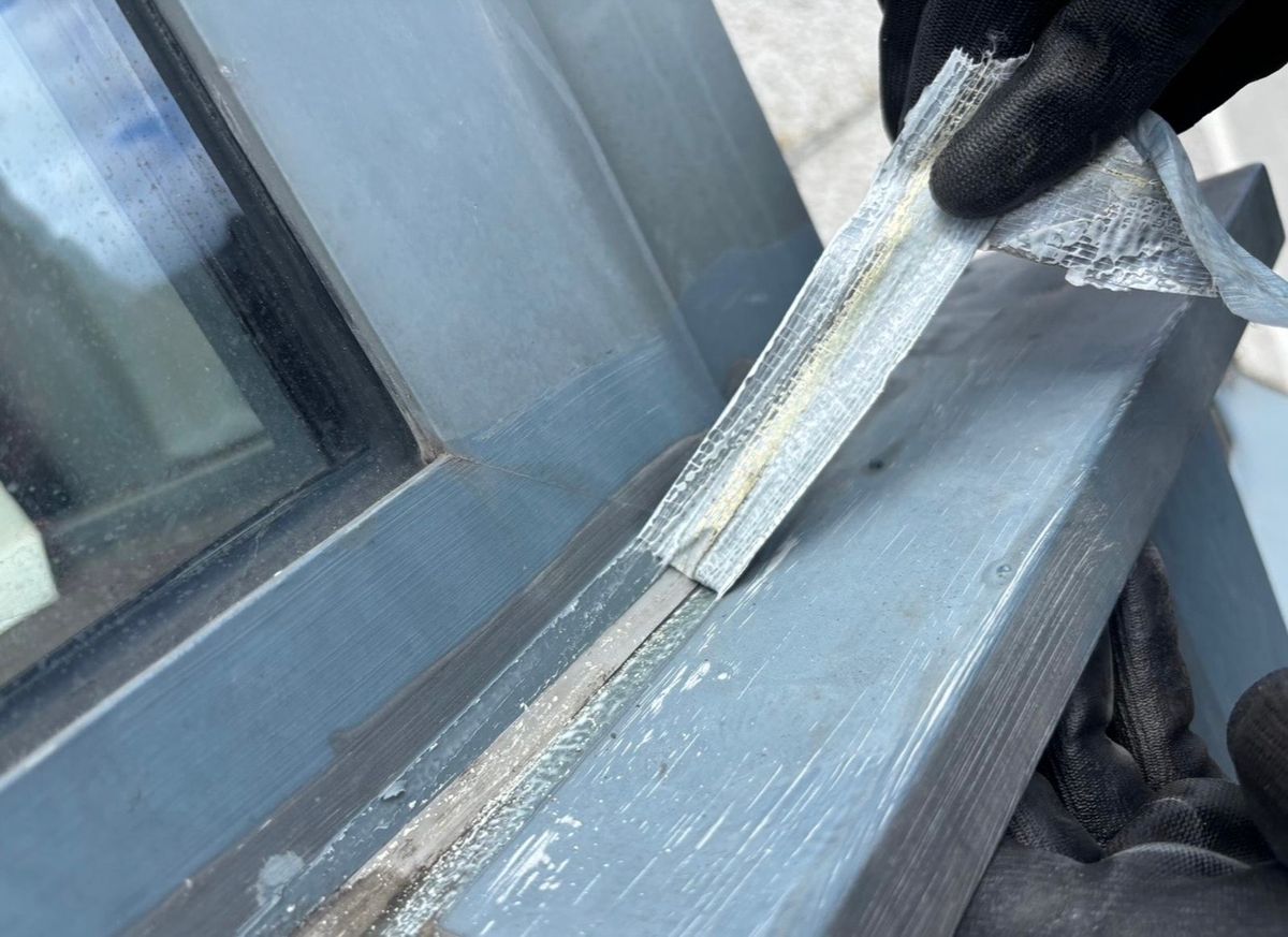 Removal of the previous repair during rope access investigation of water ingress around the high-rise window system in Newcastle upon Tyne.